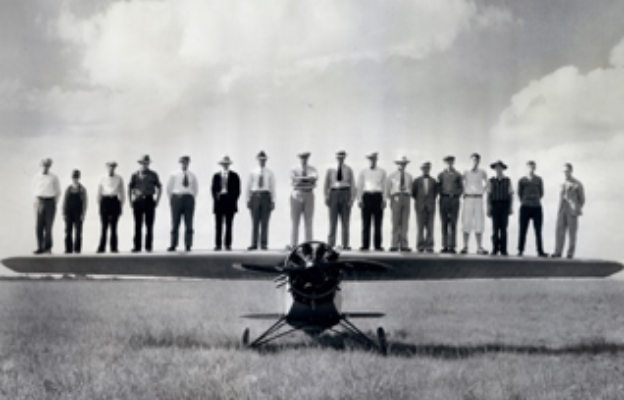 historic photo of men standing on propeller aircraft in Wichita Kansas, Air Capital of the World