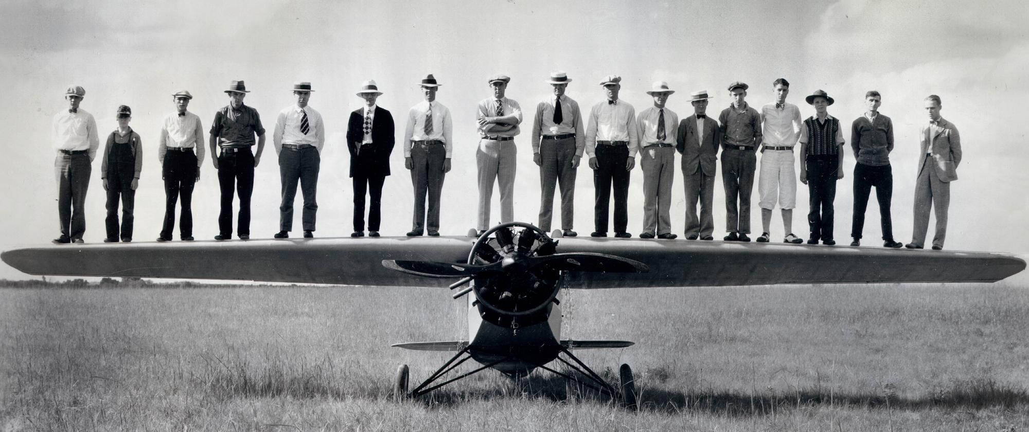 historic photo of men standing on propeller aircraft in Wichita Kansas, Air Capital of the World